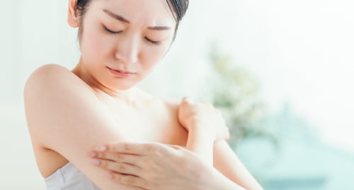 二の腕に手を添えてボディケアをする女性の写真 夏に気をつけたいデリケートケアのコラム用画像